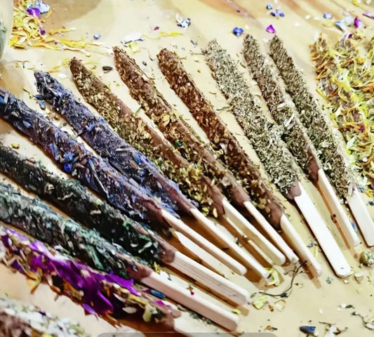 Artisan Dipped Palo Santo Ritual Sticks displayed artistically on a surface with herbs and flowers.