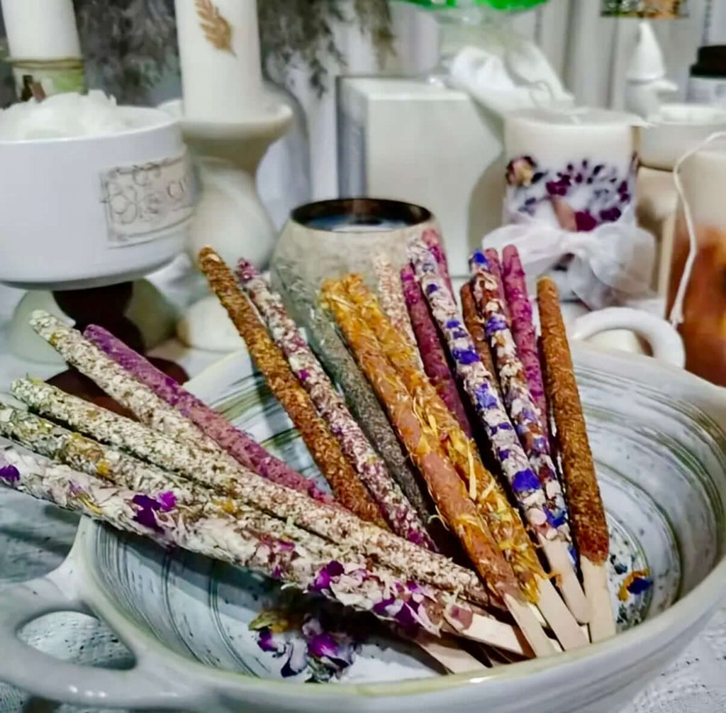Artisan Dipped Palo Santo Ritual Sticks beautifully arranged in a bowl with colorful floral accents.